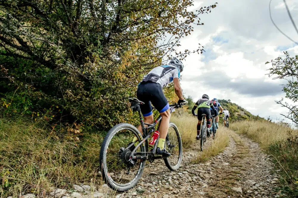 group of riders cyclists riding uphill one behind other during Crimean race mountainbike