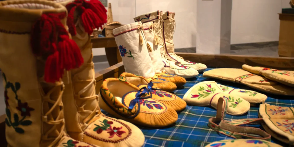 things to do in Saguenay Museum display with leather boots, moccasins, shoes and gloves made by indigenous peoples in the First Nation community of Mashteuiatsh