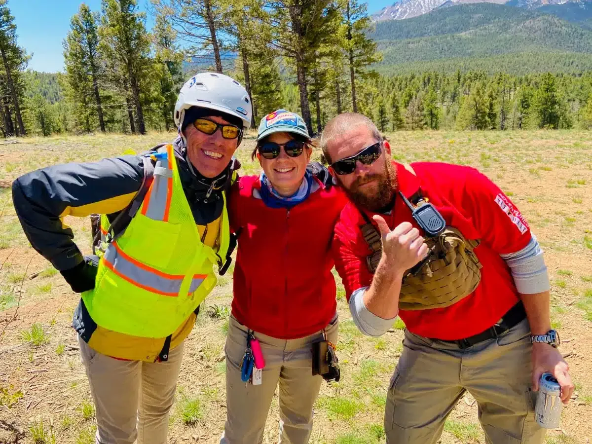 Three staff members of Adventures Out West pose for a photo during the bicycle ride of Pikes Peak.