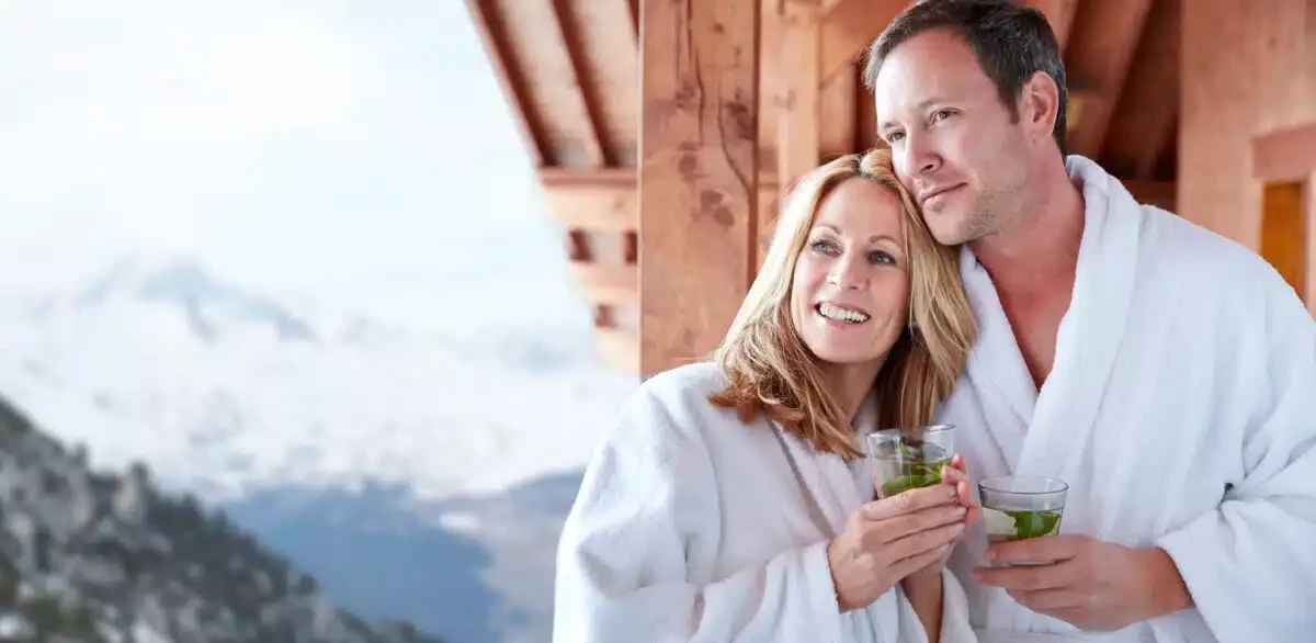 Couple in bathrobes standing on balcony together