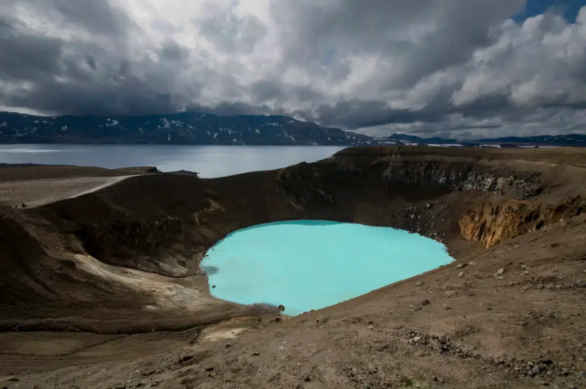 A volcanic crater filled with milky blue water. One of the best hikes in Iceland