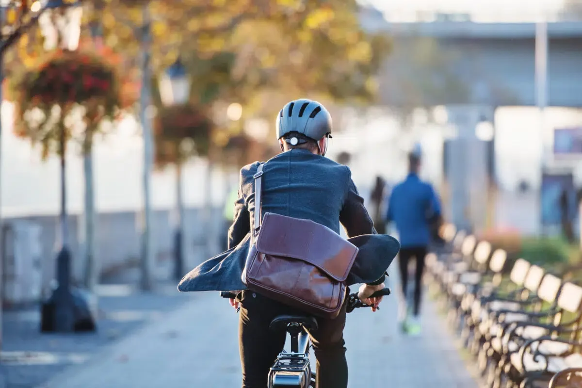 man riding an electric bike while carrying a messenger bag