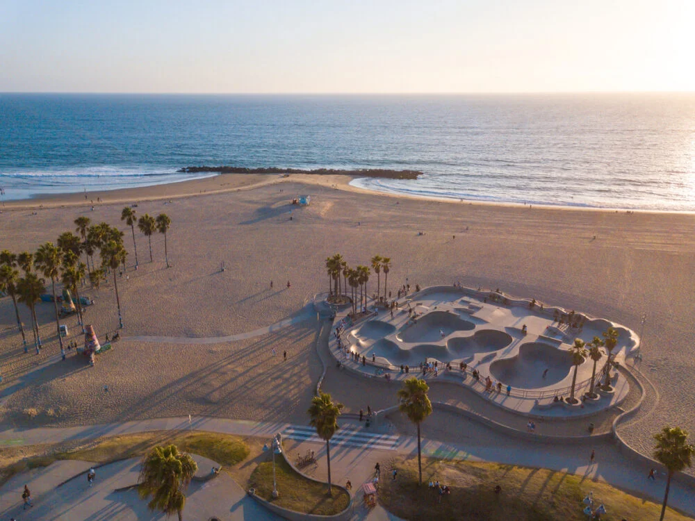 Aerial photos of the Venice Beach Skate Park taken with a drone during sunset. Long shadows of palm trees and skateboarders.