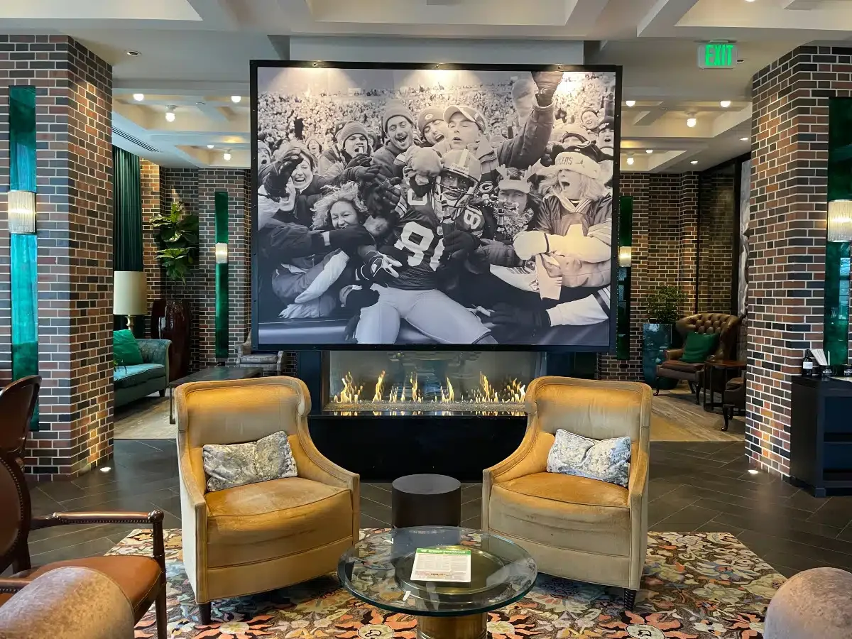 Lodge Kohler lobby with gold velvet armchairs and a large black and white photo of football players.